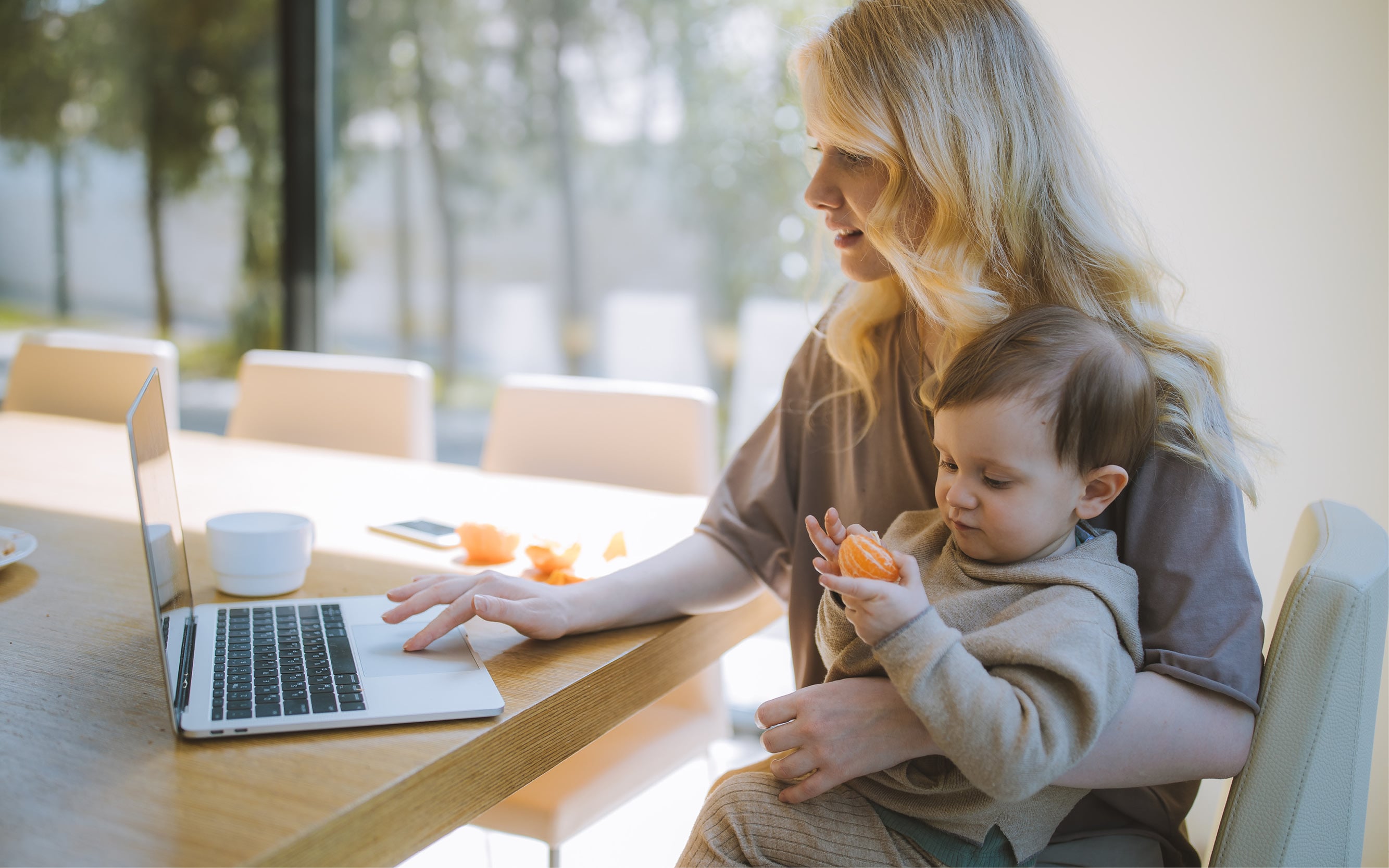 Mom with baby on her lap working on a laptop