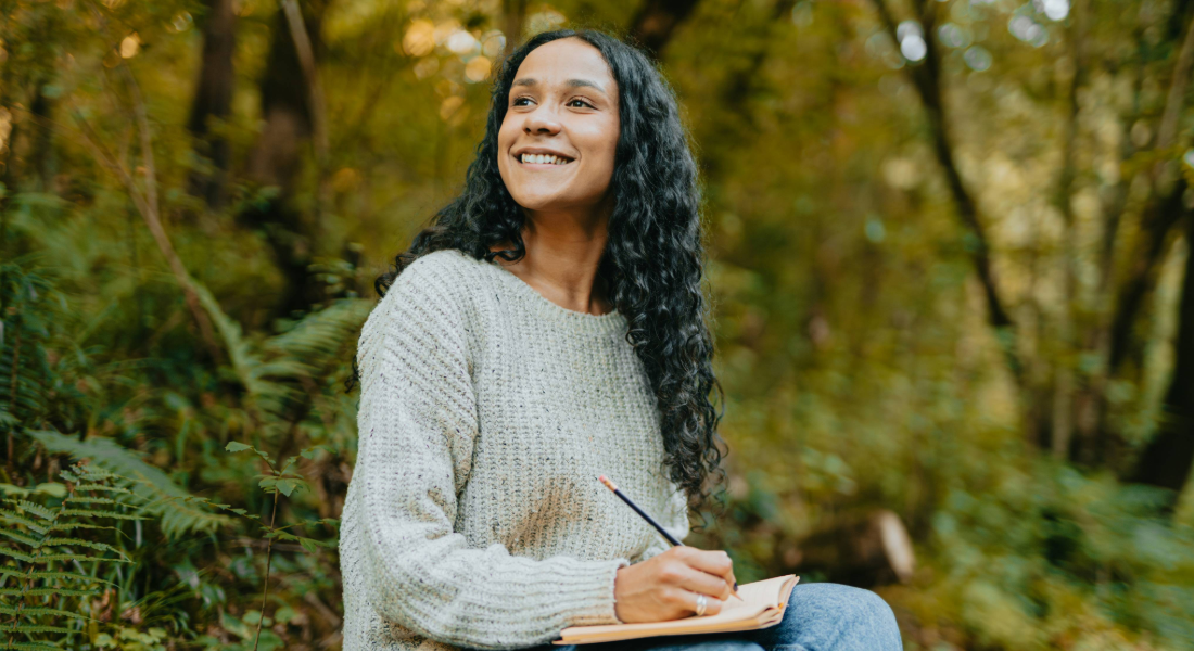 woman journaling in the woods
