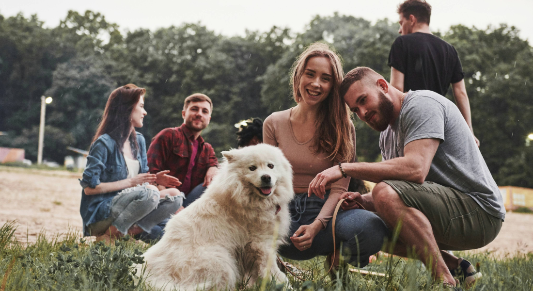 Group of young adults outdoors with dog