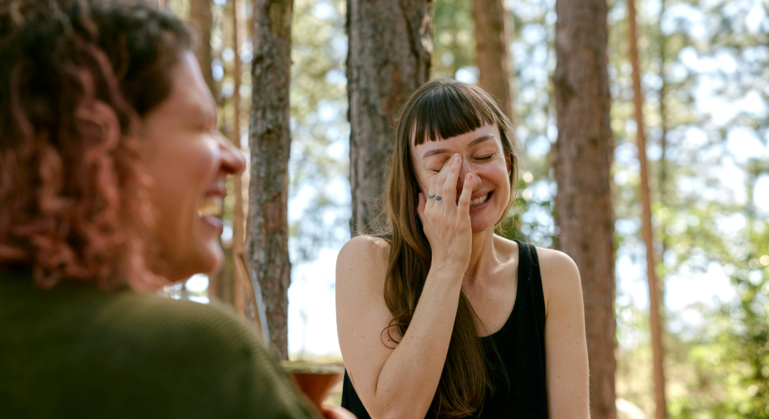 two women laughing in the woods