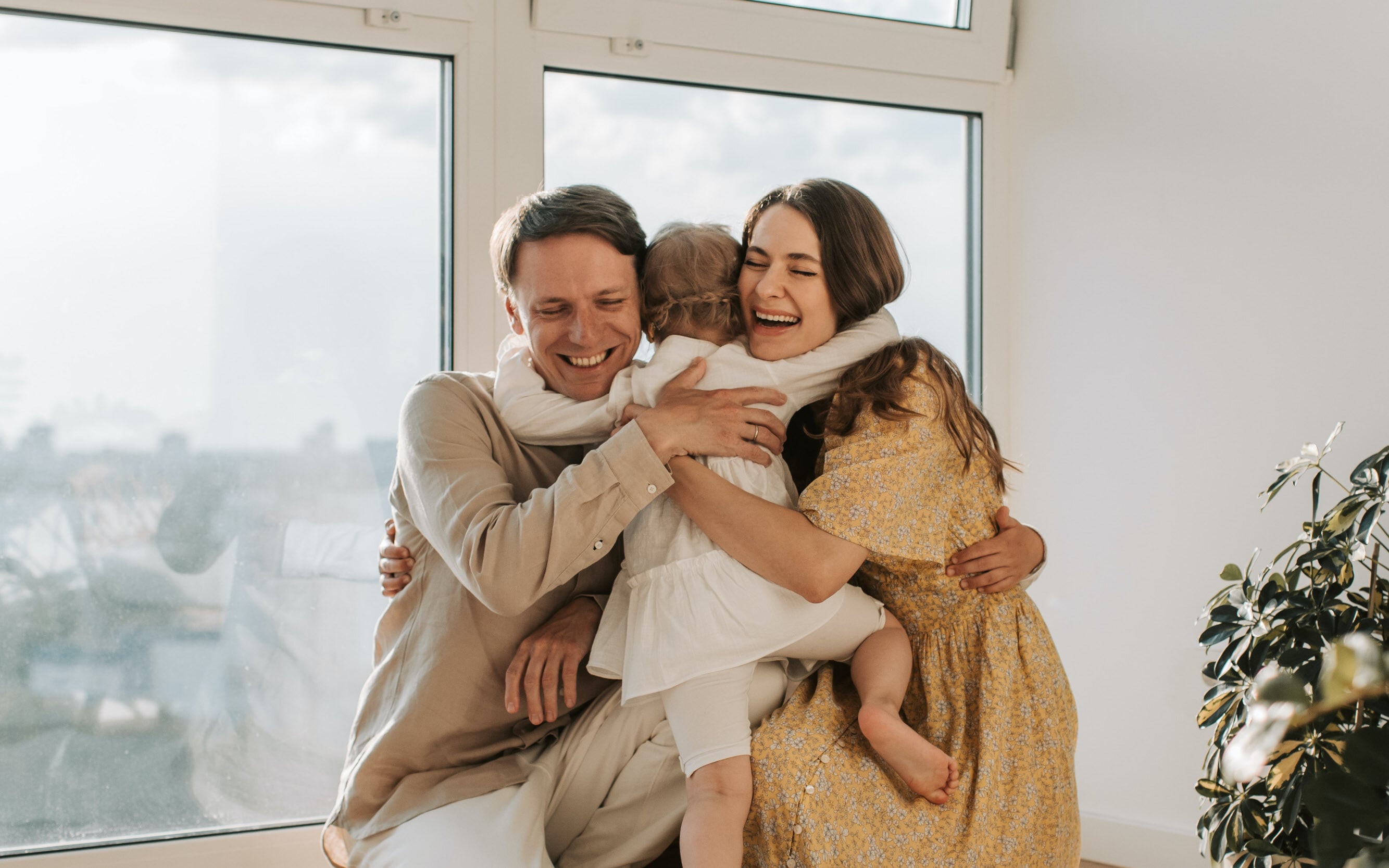 mom and dad hugging their daughter