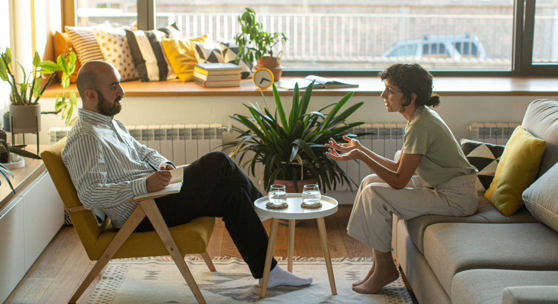 women on a couch talking to a man in a chair